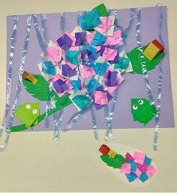 画像：おりがみで作られた色鮮やかなあじさいが中心にあり、葉っぱの上には、かえるやかたつむりが並んでいます。