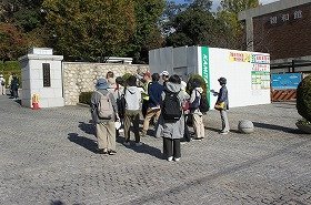 写真：まち案内人様の説明を聞いている参加者。