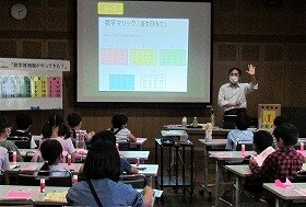 画像：講師が「誕生日当て」ゲームの説明をしているところ