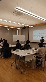 画像：説明を聞く参加者の様子。