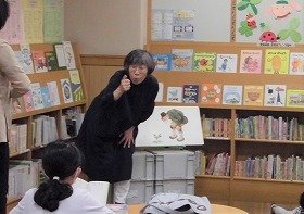 画像：吹田市聴言障害者協会のボランティアが、手話で絵本の『おおきなかぶ』を読み聞かせしている様子。