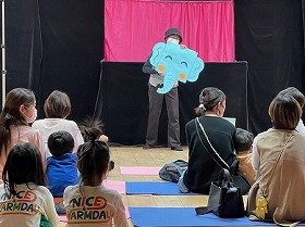 画像：ペーパーシアターで登場したぞうさんを持っている「人形劇のねこじゃらし」の演者と、それを見ている観客。