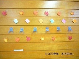 落ち葉に囲まれた、小さな椅子と本の装飾の画像