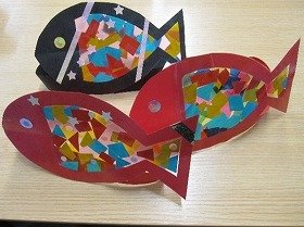 写真2：魚の形に切り取り、画用紙に、参加者が色紙やセロハンで飾り付けたもの。