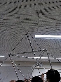 画像3：「さんかくのいえ」をかつぐ参加者たち。