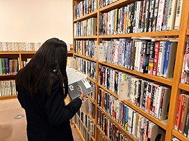 吹田市立第一中学校の生徒が予約の本を集めている画像。