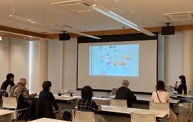 健康医療情報講座「フレイルって何？ 加齢にまけない身体づくり」で前方のスクリーンを見ながら講師の話を聞いている参加者の画像