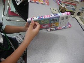 写真本の背表紙に場所を示すシールを貼っている様子