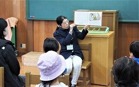 写真2：絵本の読み聞かせを聞く参加者たち。