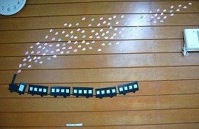 写真1：桜吹雪の中で汽車が走っている装飾。