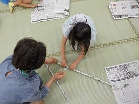 画像2：吹田子どもの本連絡会のメンバーと一緒に工作をする参加者。