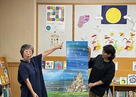 写真『パパ、お月さまとって!』の読み聞かせの様子。