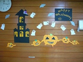 写真：かぼちゃたちが手をつないで踊り、おばけとコウモリが飛びかうハロウィンの装飾。