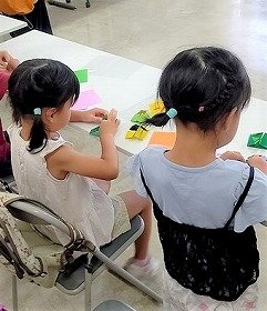 折り紙を折る子供たちの画像