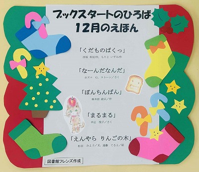 「ブックスタートのひろば」12月に読む絵本を紹介したポスター。クリスマスツリー、色とりどりの靴下やキャンディ、ヒイラギなどのクリスマスのモチーフが飾り付けられています。