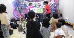 大型絵本『そらまめくんのベッド』の読み聞かせを親子で聞いている様子の画像