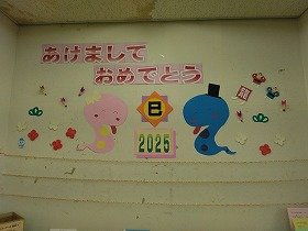 写真1 開始時、干支の蛇と正月飾りの壁面装飾の画像