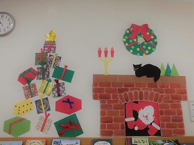 写真2：プレゼント。暖炉からサンタが覗いている。