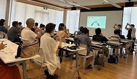 写真1 手指を使った体操をしている参加者の様子。