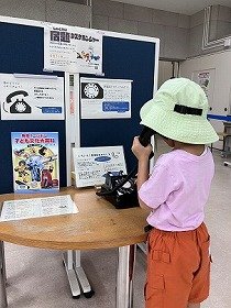 昔のどうぐにふれてみようコーナーで子供が黒電話のダイヤルを回す様子の画像