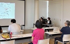 写真2 スクリーンを見ながら説明を聞いている参加者の様子。