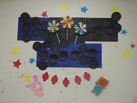 提灯の下でウサギとクマが打ち上げ花火を見上げている壁面装飾の画像