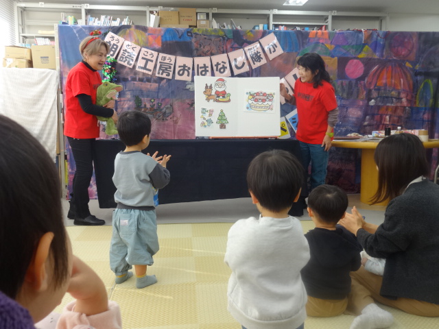 写真：パネルシアター『まほうのふくろ★クリスマス』を親子で聞いている様子