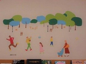 緑の小道を人々が行き交う様子の壁面装飾の画像