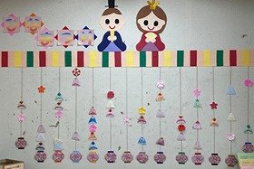 終了時、折り紙のおだいりさまとおひなさまでにぎやかになったつるし雛の壁面装飾の画像
