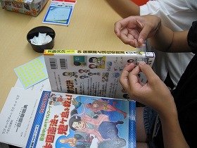 本の背表紙に場所を示すシールを貼っている様子の画像