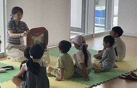 紙芝居の読み聞かせを真剣に聞く子供たちの様子の画像