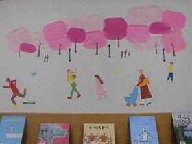 桜並木を人々が行き交う様子の壁面装飾の画像