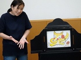 紙芝居を演じるメンバーの様子の画像