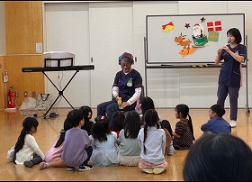 写真1：おんがく・さ～くる・コスモスさんの演奏を聴いている子供たちの写真です。