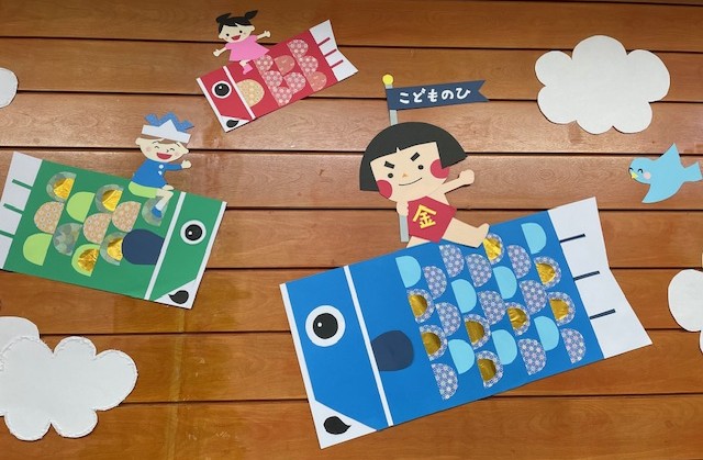 写真こいのぼりに乗った金太郎と子供が空を飛ぶ様子。