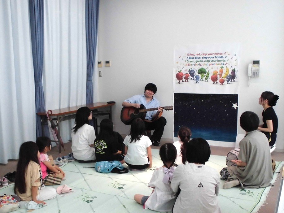 写真5：学生のギター演奏に合わせて皆で歌を歌っている。