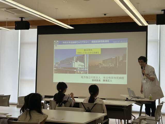 写真健康医療情報講座「聞きたい！医療のお仕事　薬剤師編」でスクリーンを見ている参加者の様子。