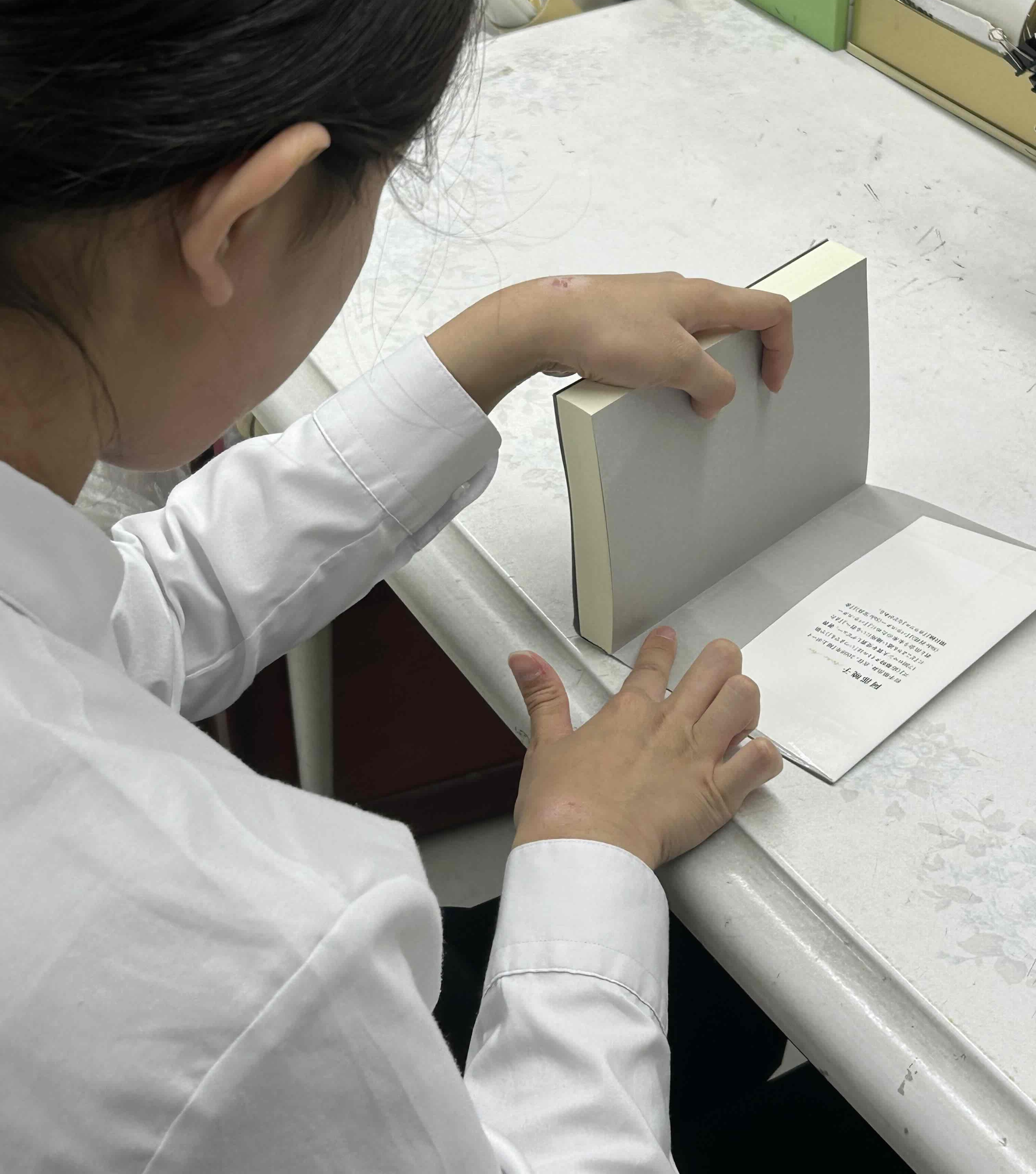 実習生が本のコーティング作業をしている様子