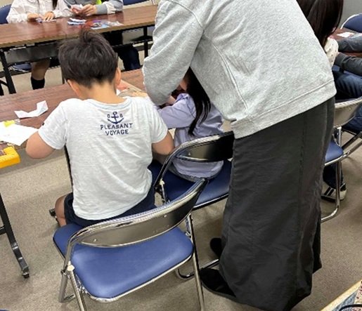 写真親子で折紙を折っている様子。