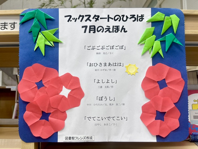 写真：「ブックスタートのひろば」で7月に読む絵本を紹介したポスター。ポスターには笹の葉と、赤色が鮮やかな花があしらわれています。