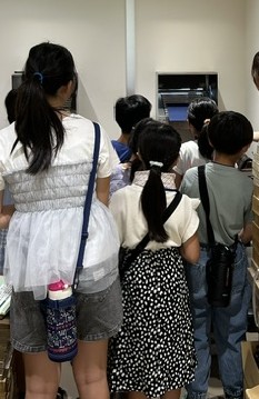返却ポスト室で本が返却されるところを見学している様子