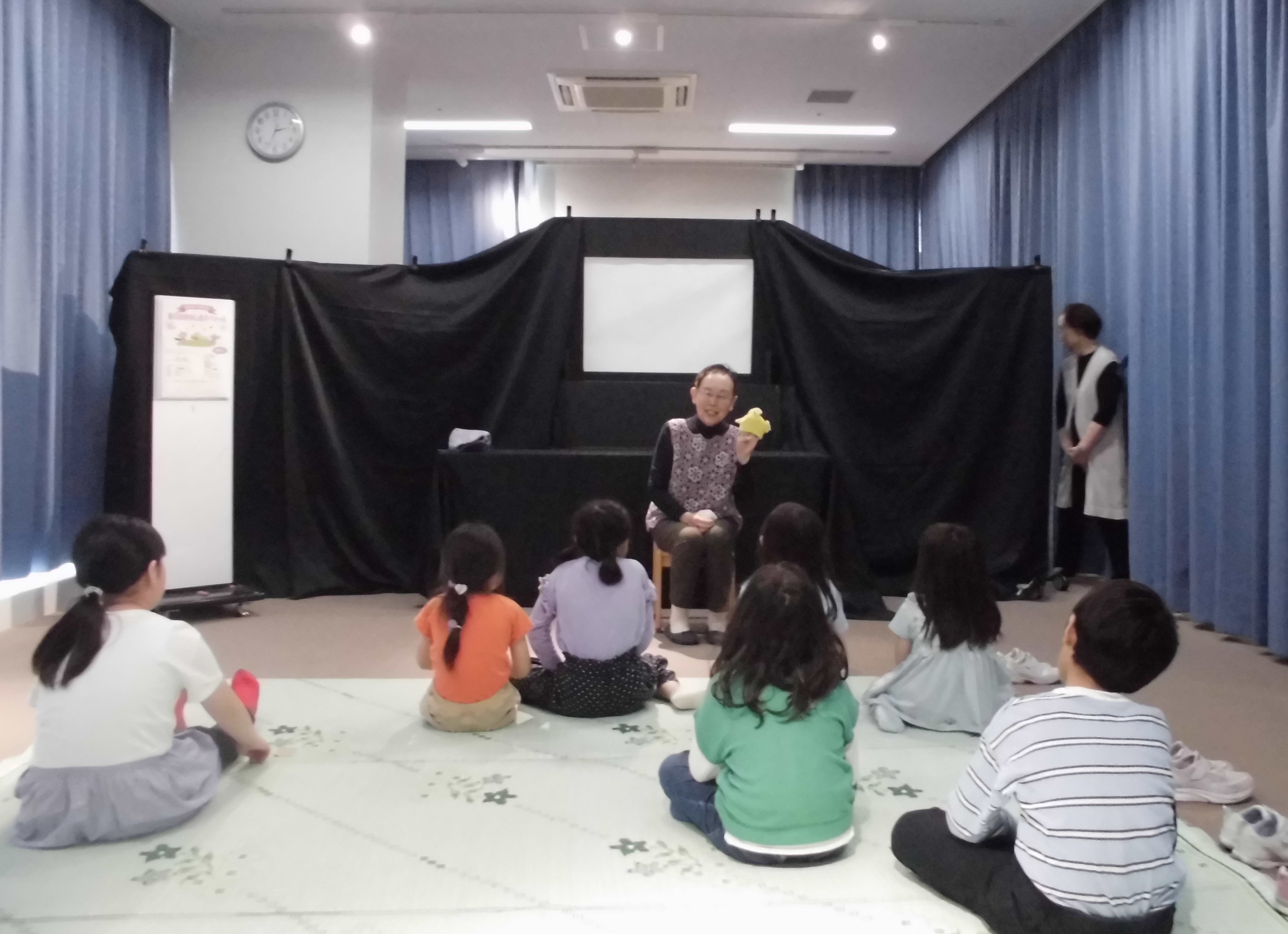 写真吹田おはなしの会の方が人形の手遊び「ころころたまご」をしているところ