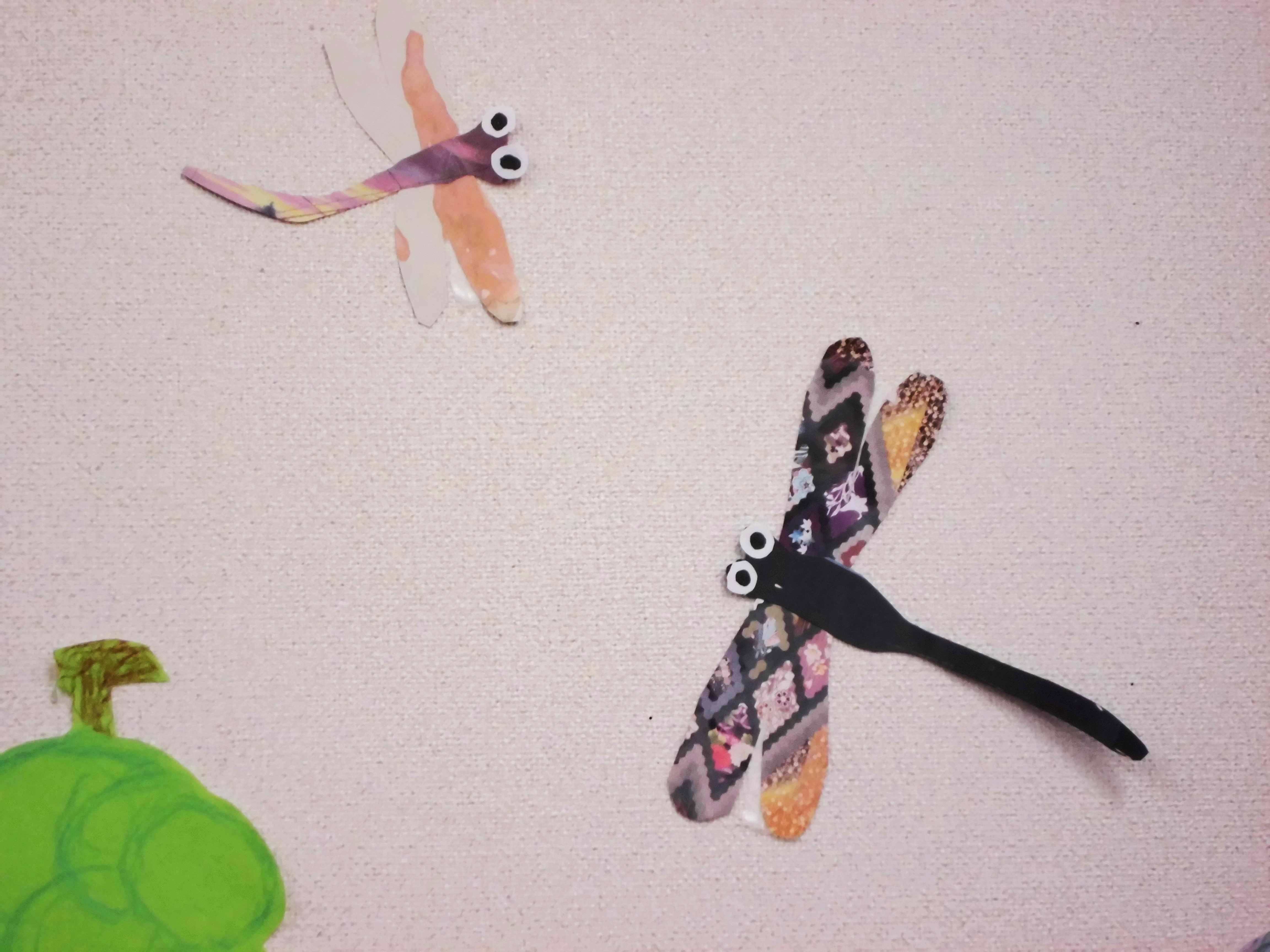 写真2：トンボが2匹飛んでいます。羽がカラフルに作られています。