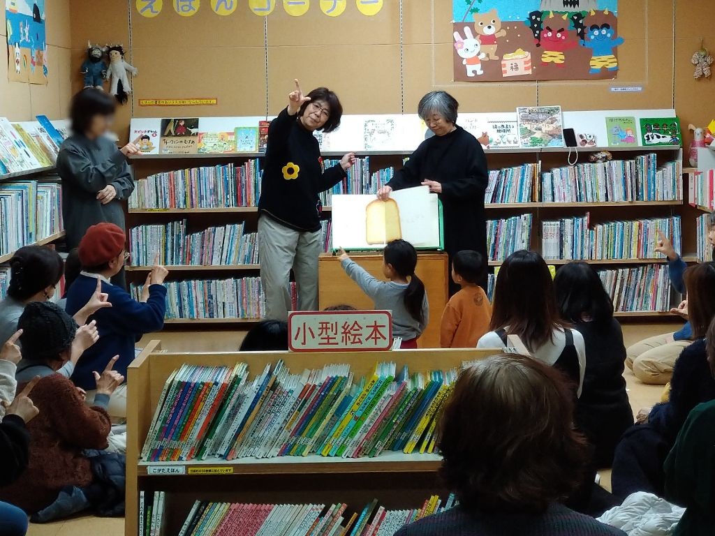 写真2：手話での読み聞かせで、参加者も一緒に手話をしている様子