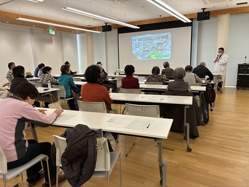 写真1：健康医療情報講座「知っておきたい『がん』のこと」でスクリーンを見ながら講師のお話を熱心に聴いている参加者の様子。