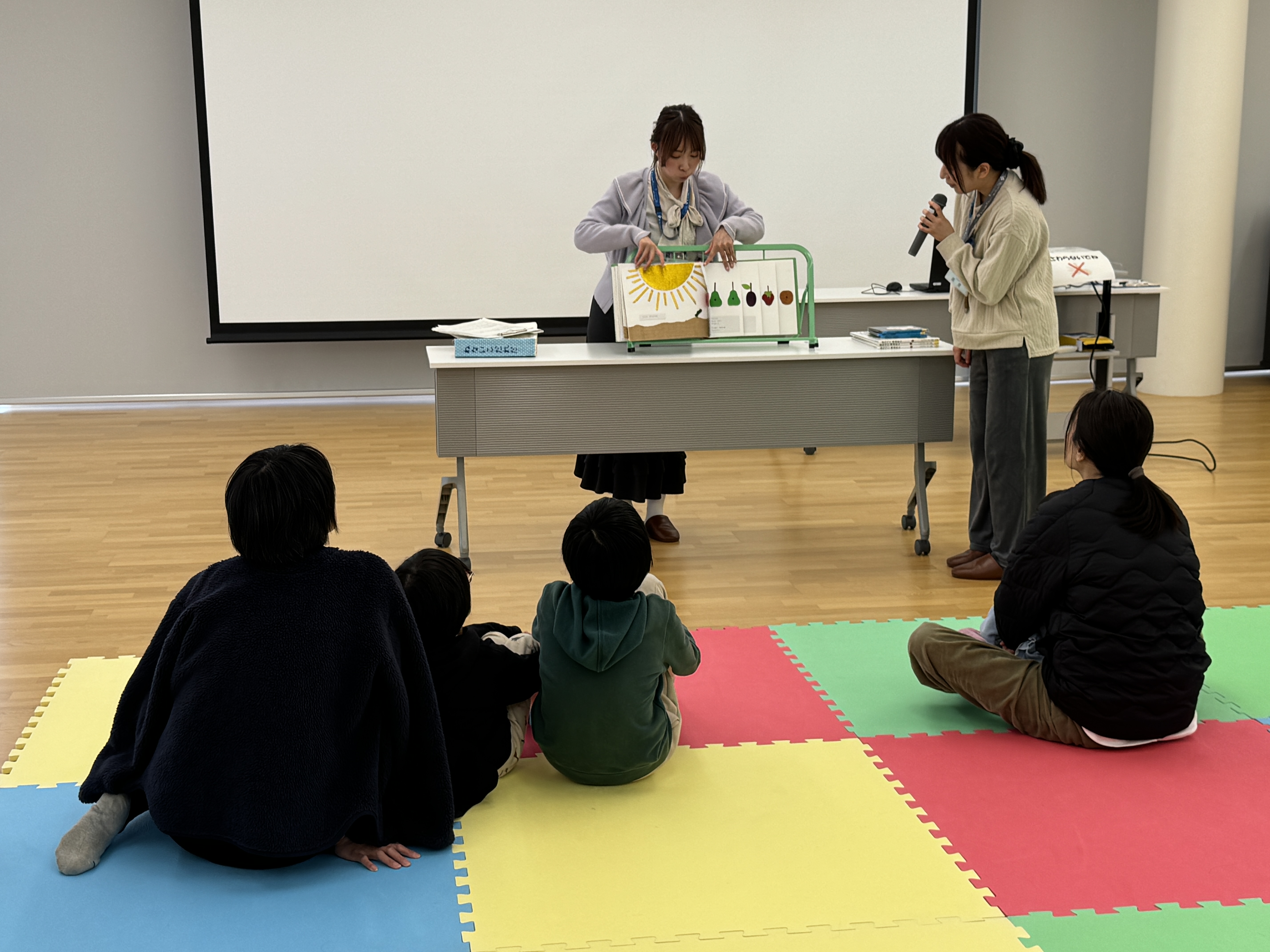 画像点字つきさわる絵本のはらぺこあおむしを読み聞かせしている様子。