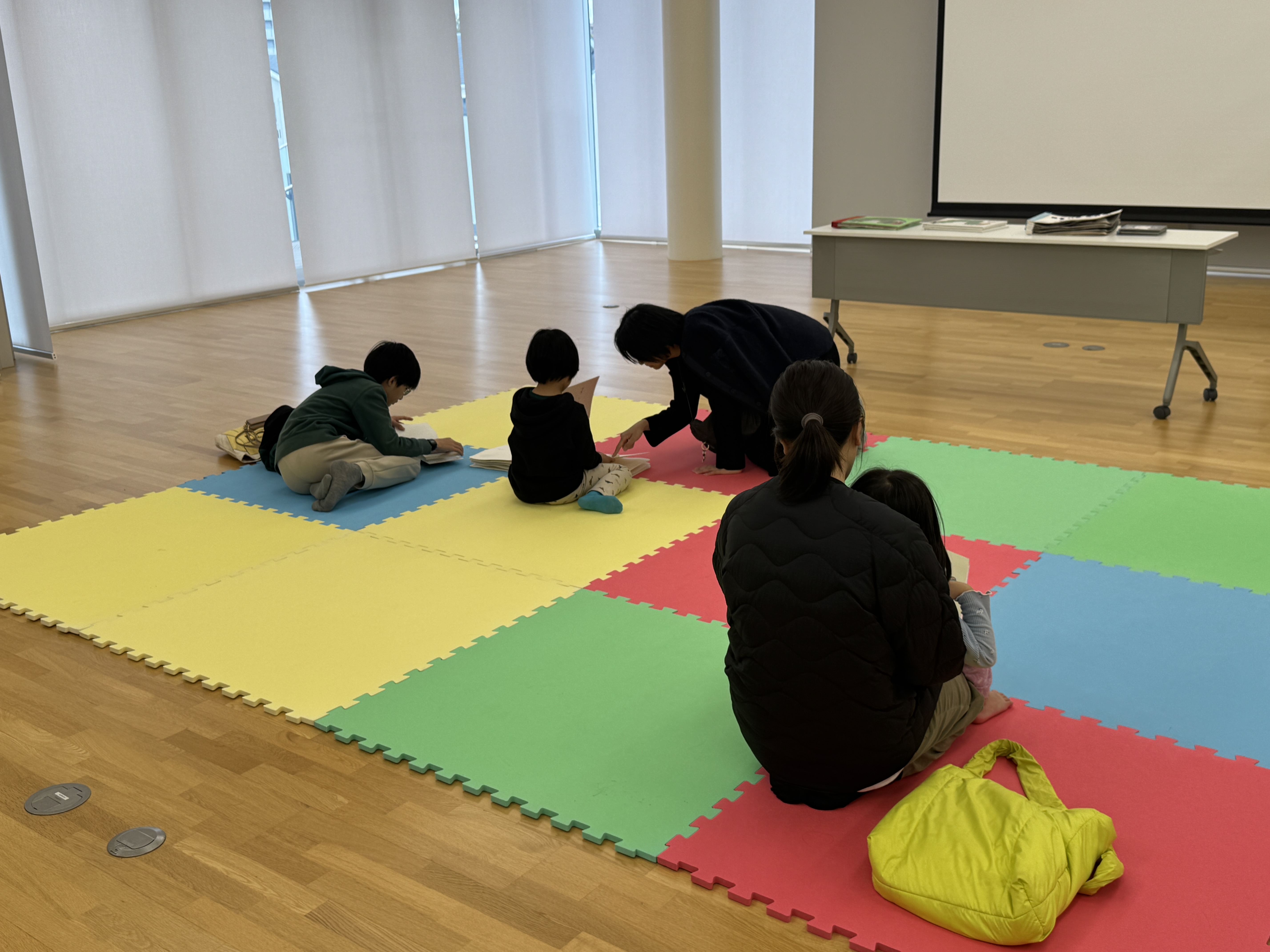 画像参加者がさわる絵本やLLブックをマットの上で読んでいる様子。