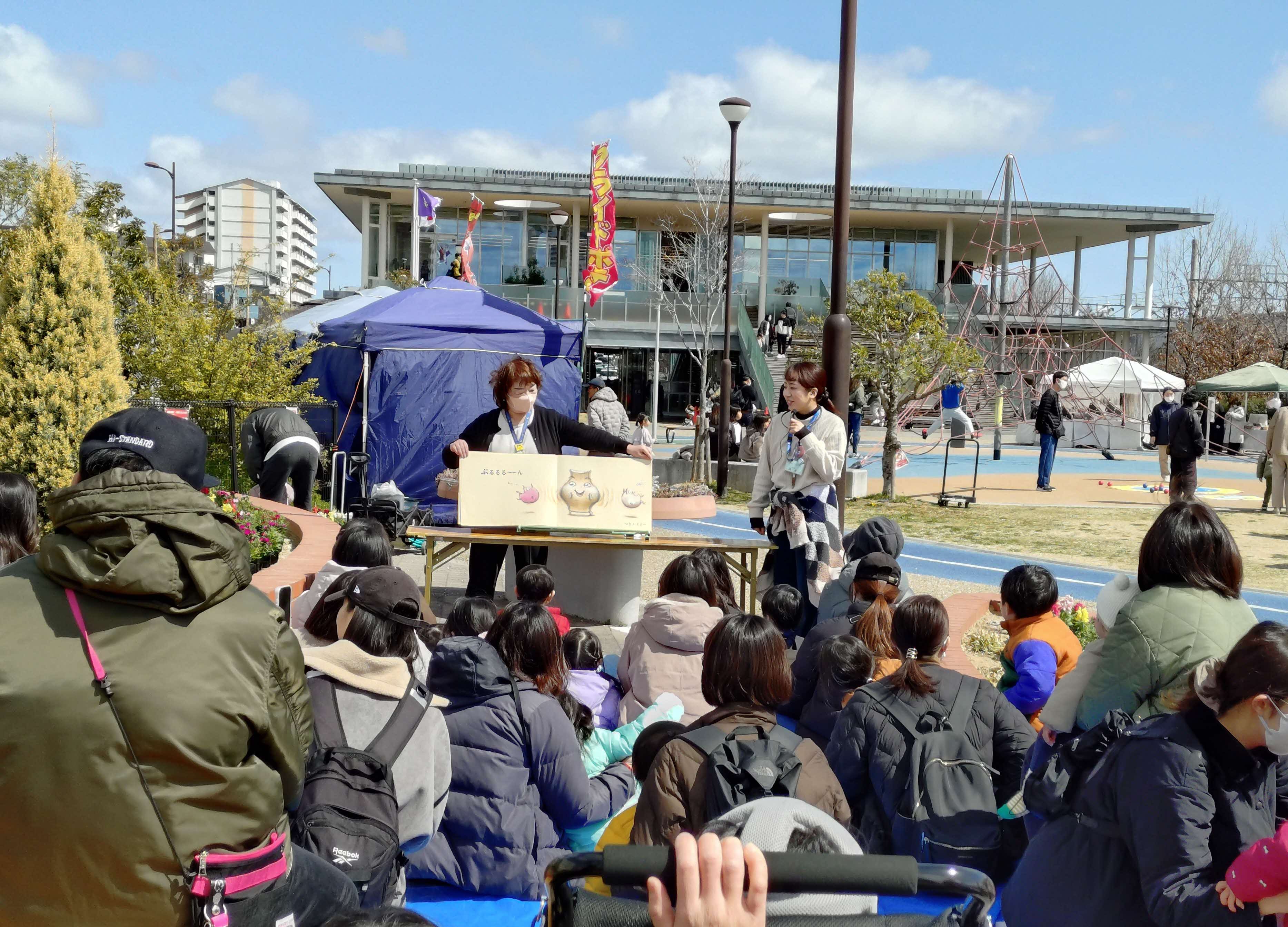 写真子供たちに、大型絵本『おしくらまんじゅう』を読んでいる様子。