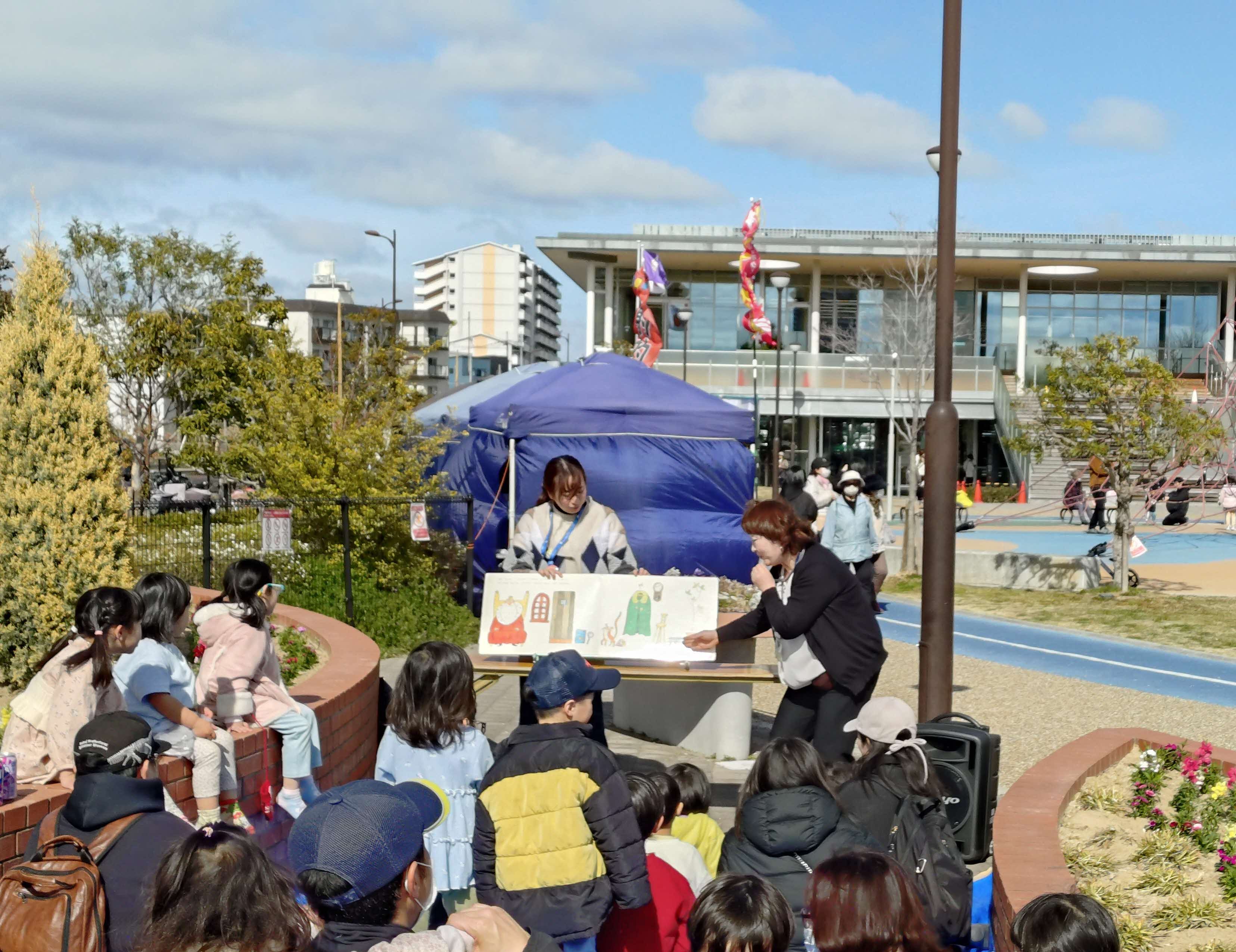 写真子供たちに、大型絵本『しりとりのだいすきなおうさま』を読んでいる様子。