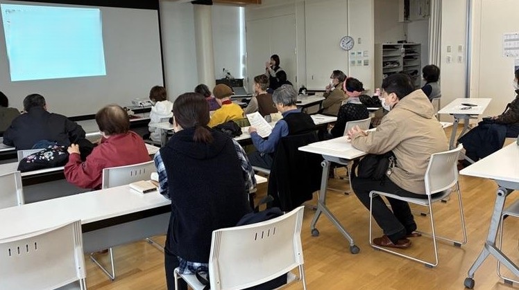 写真健康医療情報講座「認知症と薬」で講師のお話に耳を傾けながら前方のスクリーンを見ている参加者の様子。